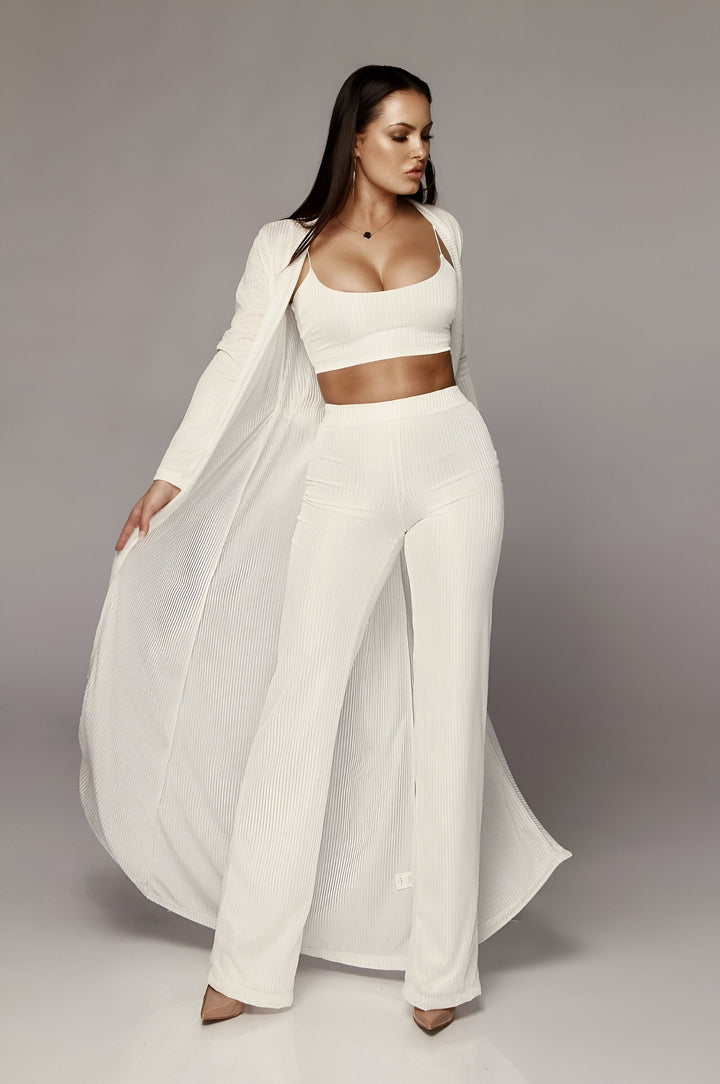 Femme portant un kimono long blanc plissé, un crop top et un pantalon assortis. Collection de kimonos élégants et confortables.
