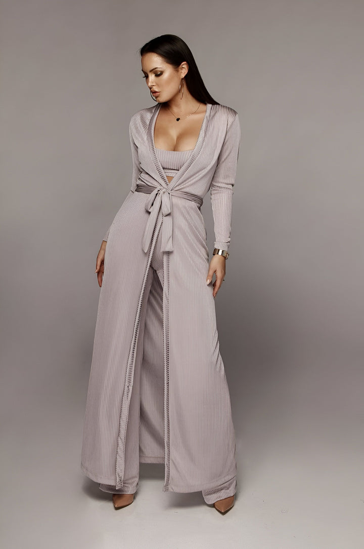 Femme portant un kimono en velours côtelé gris, avec pantalon ample et haut court. Élégance et confort pour votre intérieur. Découvrez notre collection de kimonos.