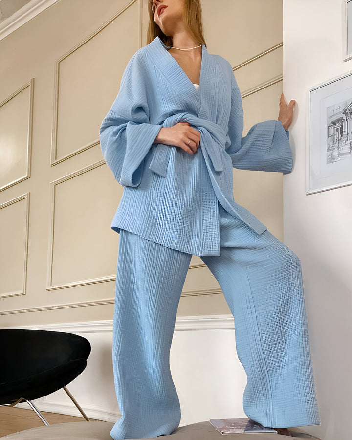 Femme portant un kimono bleu en mousseline de coton avec pantalon assorti. Vêtements d'intérieur confortables et élégants. Kimonos de qualité à découvrir dans notre boutique en ligne.