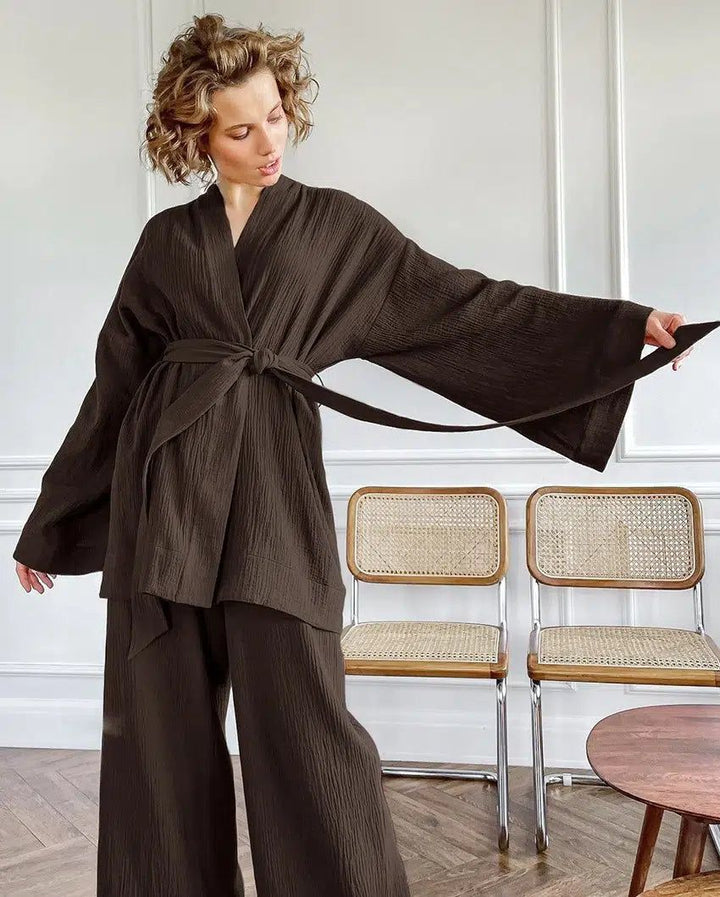Femme portant un kimono marron avec pantalon assorti. Ensemble kimono confortable et élégant, idéal pour la détente ou une tenue décontractée. Découvrez notre collection de kimonos pour tous les styles.