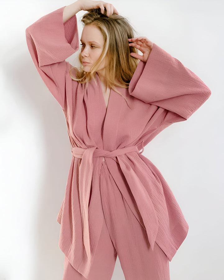 Femme portant un kimono rose avec une ceinture, manches larges. Vêtements style kimono. Kimonos en vente. Mode japonaise.