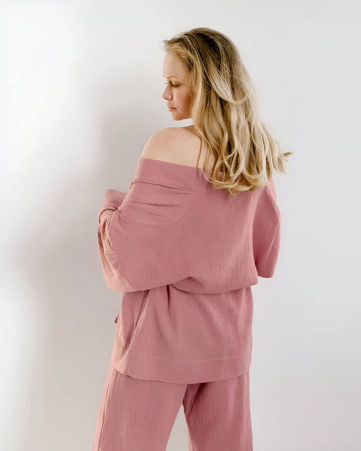 Femme blonde portant un kimono rose pastel. Ensemble kimono confortable et élégant. Vêtements de détente de notre collection kimono.