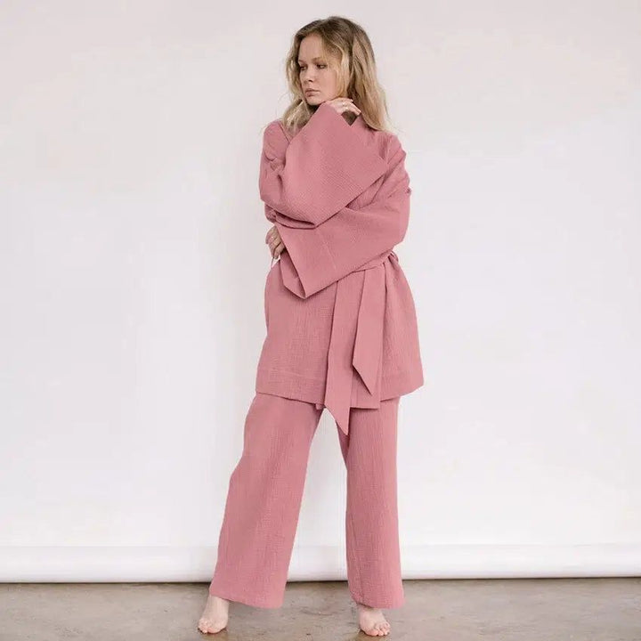 Femme portant un kimono rose avec pantalon assorti. Ensemble confortable et élégant. Vêtements japonais traditionnels revisités. Boutique de kimonos en ligne.