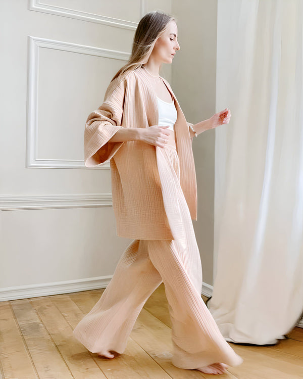 Femme portant un kimono pêche avec un pantalon assorti. Tenue d'intérieur confortable et élégante. Vêtements de détente de luxe. Nouveau kimono tendance.
