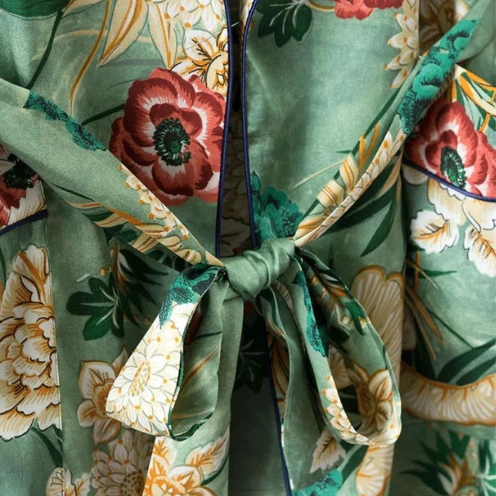 Détail d'un kimono vert avec imprimé floral et ceinture nouée. Vêtements traditionnels japonais, motifs floraux, style élégant. Idéal pour une tenue confortable et tendance.