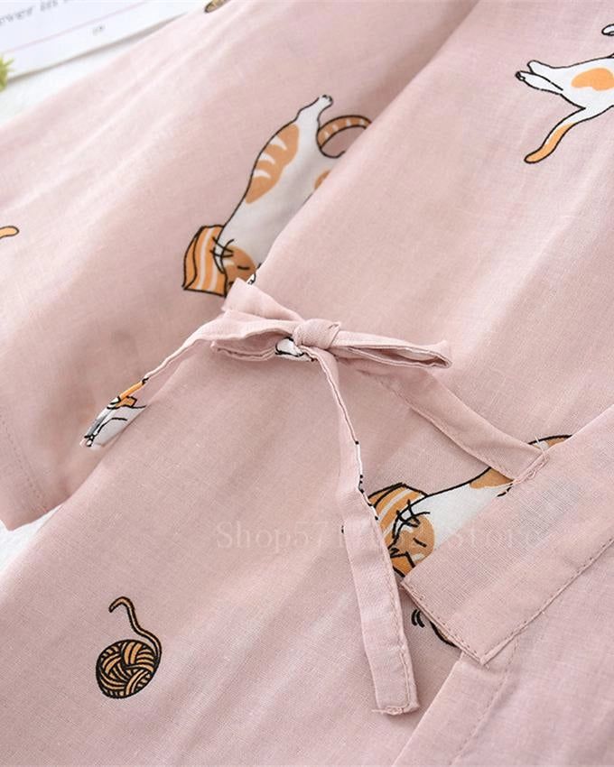 Kimono rose clair avec motifs de chats et pelotes de laine. Détail du nœud de fermeture. Vêtements de détente confortables et stylés.