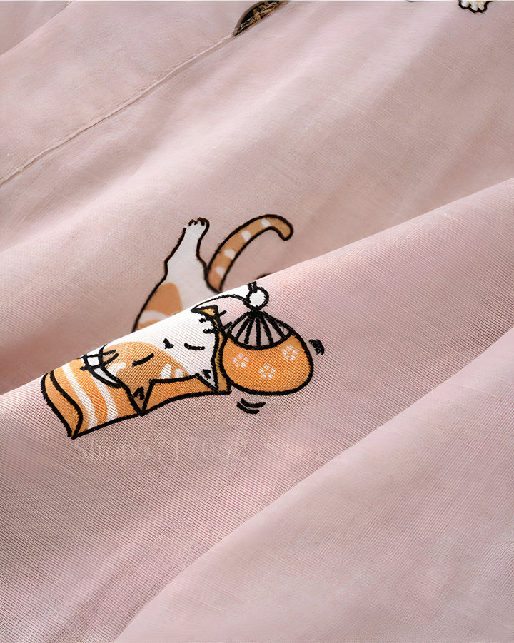 Détail de tissu rose pour kimono avec motif de chats mignons. Chat voyageur avec sac et chat allongé. Vêtements japonais originaux.