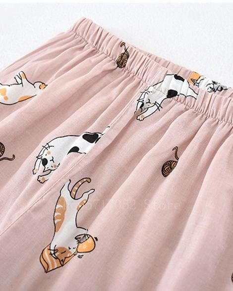 Pantalon de pyjama rose clair avec motif de chats et de pelotes de laine. Vêtement de détente confortable, idéal pour compléter un kimono de nuit.