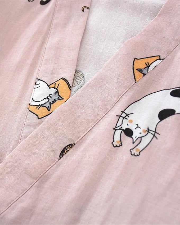Détail d'un kimono rose avec des motifs de chats mignons. Idéal pour les amoureux des chats. Kimono confortable et stylé.