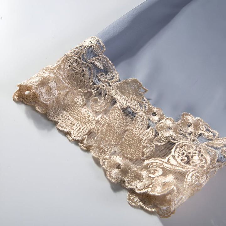 Détail raffiné d'un kimono : manche en soie bleu pâle ornée de dentelle florale beige. Élégance et délicatesse pour votre tenue d'intérieur. Découvrez nos kimonos uniques.