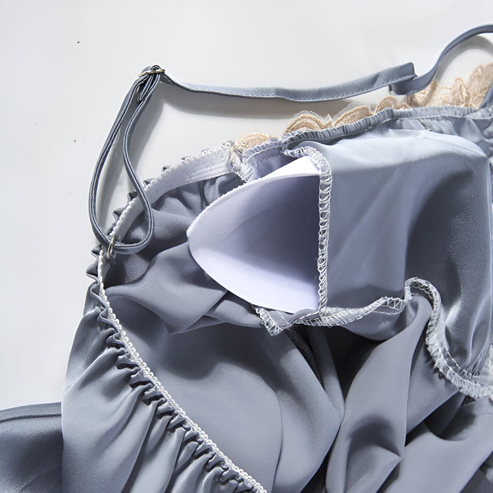 Détail d'un kimono gris avec bretelles et dentelle, révélant une doublure blanche. Vêtement de nuit élégant, disponible dans notre collection de kimonos.