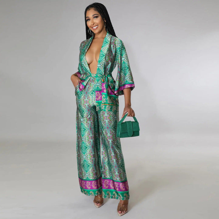 Femme souriante portant un kimono vert à motifs avec pantalon assorti. Look tendance, style kimono. Sac à main vert. Découvrez notre collection de kimonos élégants.