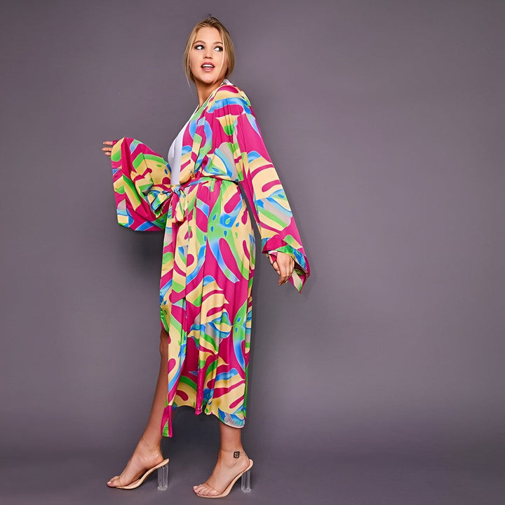Femme portant un kimono coloré à motifs abstraits. Vêtements de détente élégants, parfait pour la maison ou la plage. Découvrez notre collection de kimonos.