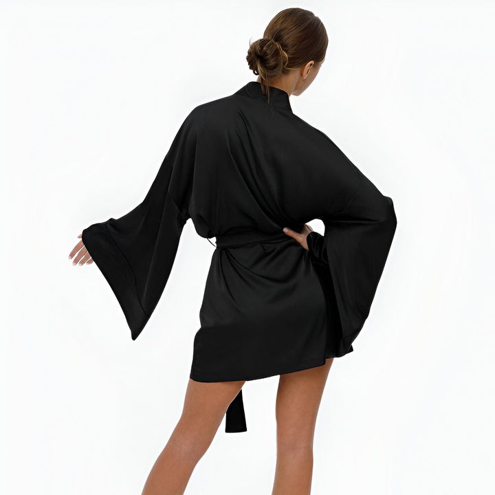 Vue arrière d'une femme portant un kimono noir avec de larges manches. Vente de kimonos en ligne.