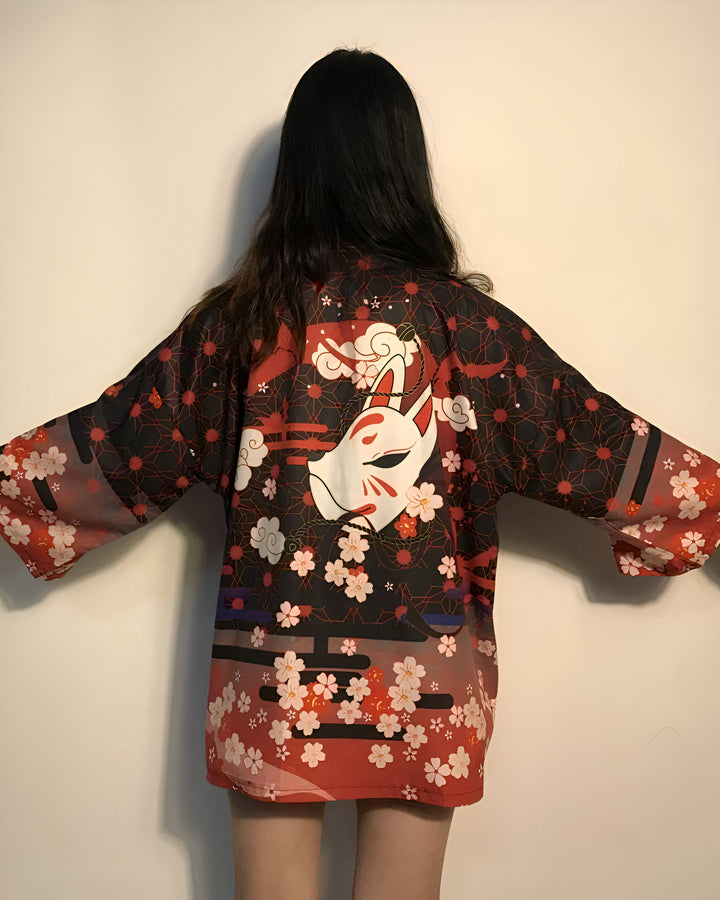 Femme portant un kimono rouge et noir avec un motif de renard et des fleurs de cerisier. Kimonos en vente.