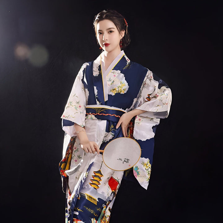 Femme portant un kimono traditionnel japonais bleu et blanc avec motifs floraux et de paysages. Elle tient un éventail rond. Kimonos à vendre.