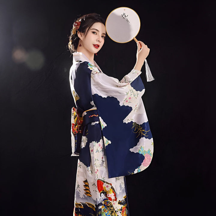 Femme portant un kimono japonais traditionnel avec motifs bleus et blancs, tenant un éventail. Vêtements japonais élégants. Kimonos disponibles à l'achat.