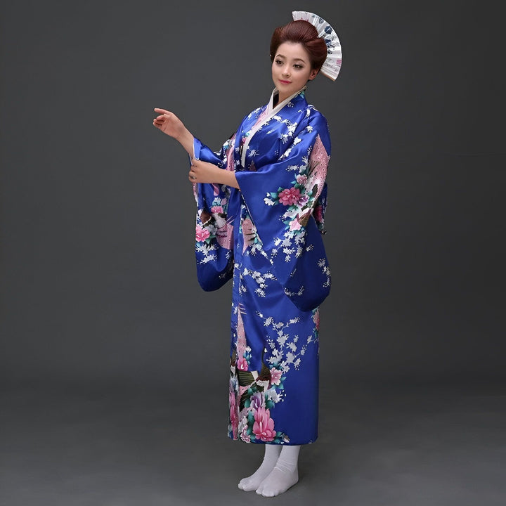 Femme portant un kimono bleu traditionnel avec des motifs floraux et un éventail. Vêtements japonais authentiques à vendre.