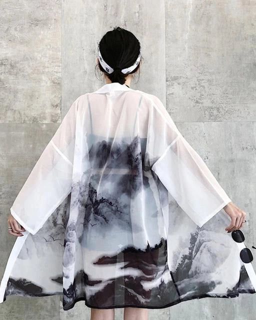 Kimono transparent blanc avec imprimé paysage de montagne, dos de femme avec bandeau. Vêtements traditionnels japonais revisités. Idéal pour un look bohème et élégant.