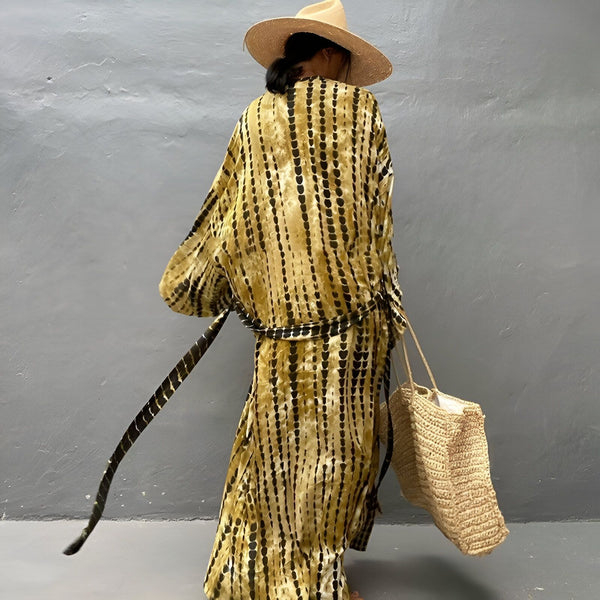 Femme portant un kimono tie-dye marron et noir avec un chapeau de paille et un sac à main en paille. Vêtements kimono en vente.