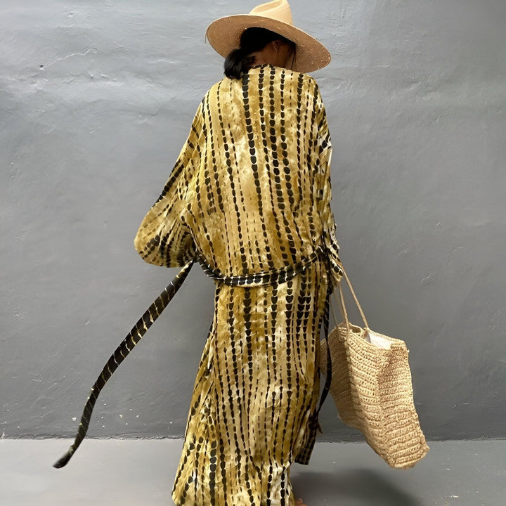 Femme portant un kimono tie-dye marron et noir avec un chapeau de paille et un sac à main en paille. Vêtements kimono en vente.