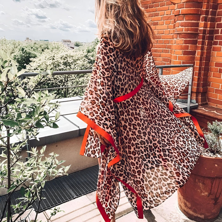 Femme portant un kimono léopard avec bordure rouge. Vêtements d'extérieur élégants. Mode kimono pour femme. Achetez des kimonos en ligne.