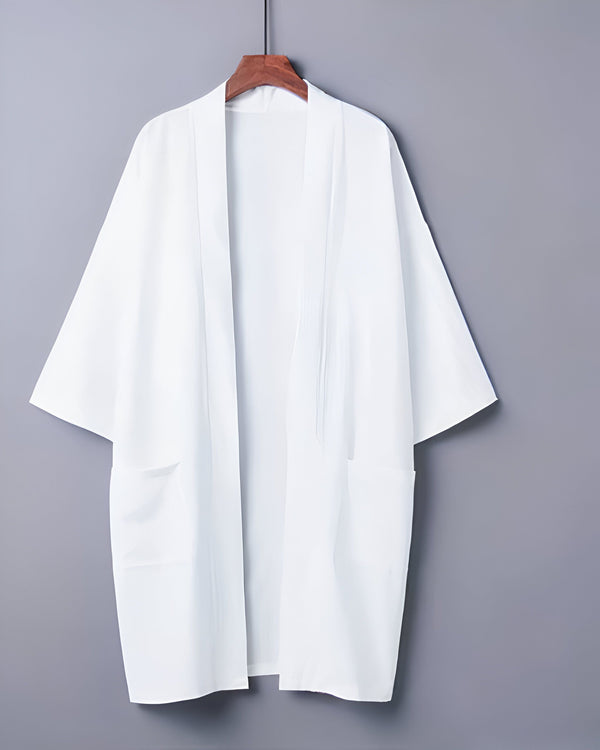 Kimono blanc sur cintre en bois. Vêtement traditionnel japonais, ample et confortable. Idéal pour la détente à la maison ou un style décontracté. Découvrez notre collection de kimonos.