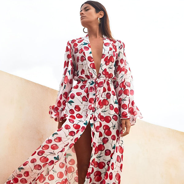 Femme portant un kimono long à imprimé cerises rouges, manches longues. Vêtements de plage et d'intérieur légers et élégants de notre collection kimono.