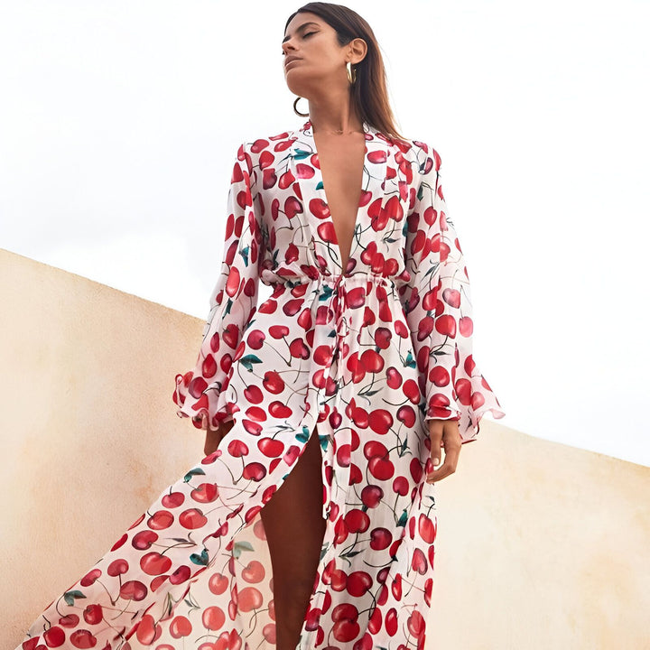Femme portant un kimono long à imprimé cerises rouges, manches longues. Vêtements de plage et d'intérieur légers et élégants de notre collection kimono.