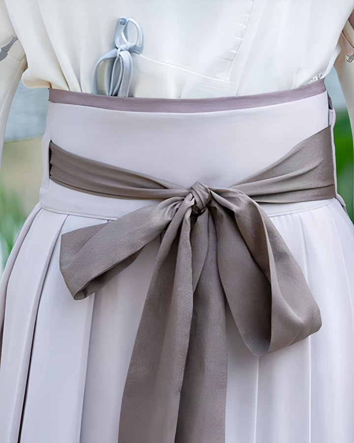 Détail d'un kimono blanc avec une large ceinture nouée en satin gris. Vêtements japonais traditionnels. Kimonos de haute qualité à vendre.