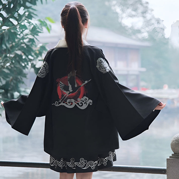 Femme portant un kimono noir avec motif de grue. Vue de dos, style japonais, disponible à l'achat. Idéal pour un look unique et tendance.