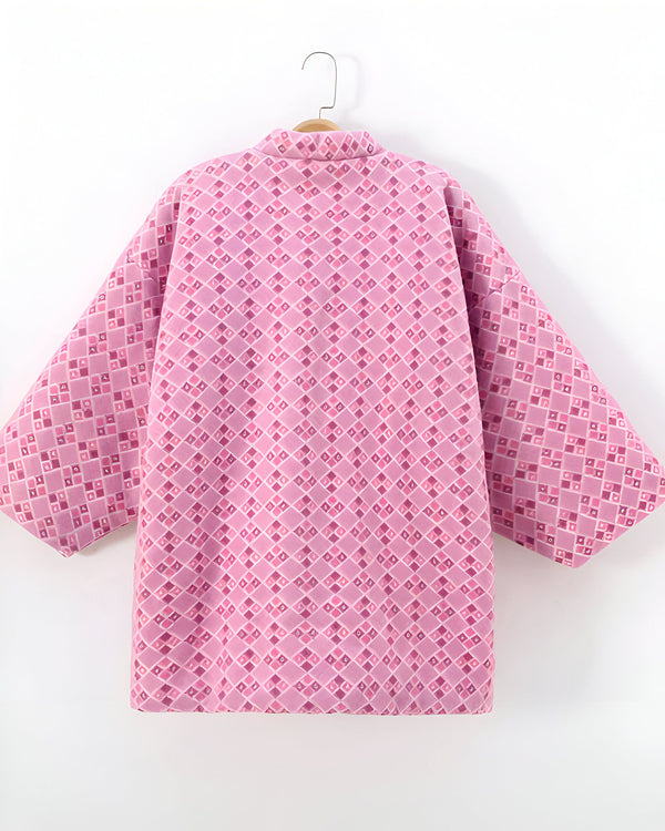 Kimono rose à motifs géométriques sur un cintre. Vêtement traditionnel japonais, parfait pour une touche d'élégance. Découvrez notre collection de kimonos uniques.
