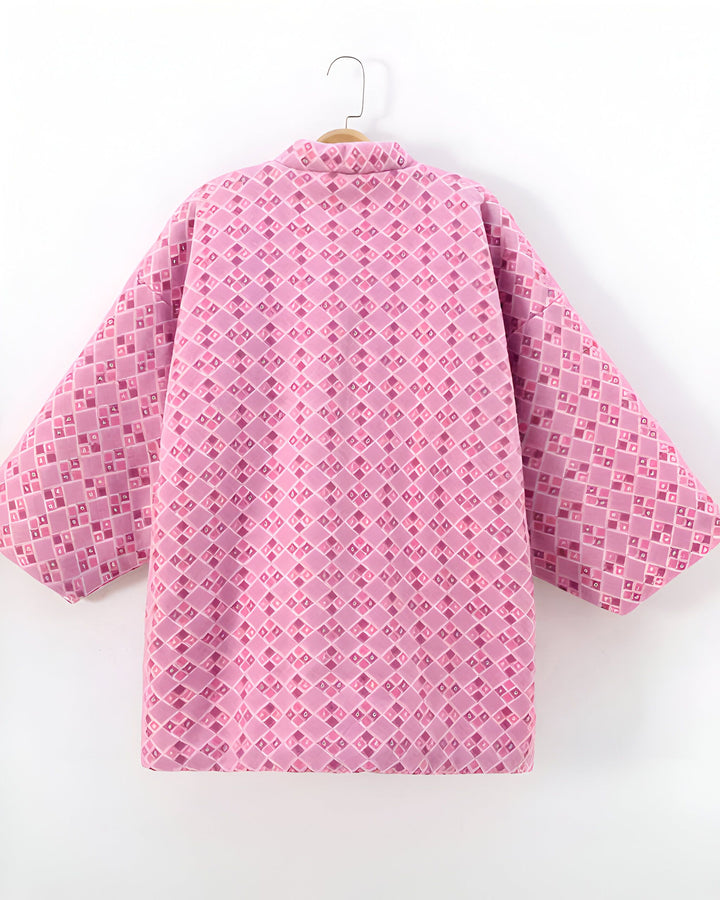 Kimono rose à motifs géométriques sur un cintre. Vêtement traditionnel japonais, parfait pour une touche d'élégance. Découvrez notre collection de kimonos uniques.