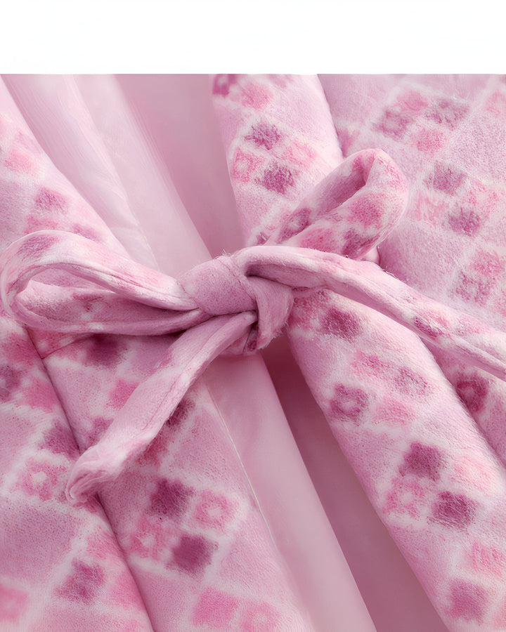 Détail d'un kimono rose à motifs avec une ceinture nouée. Kimonos disponibles à l'achat.