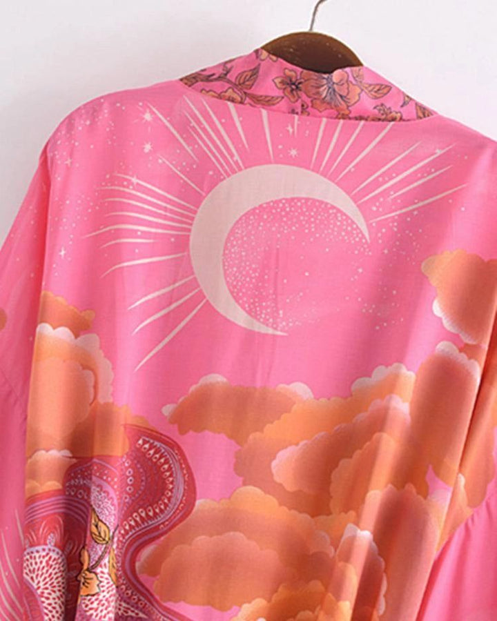Kimono rose avec motif soleil, nuages et détails floraux au col. Vêtement d'extérieur original et tendance. Découvrez notre collection de kimonos uniques.