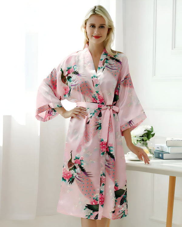 Femme portant un kimono rose à motifs de paon. Peignoir en soie confortable et élégant. Boutique de kimonos en ligne.