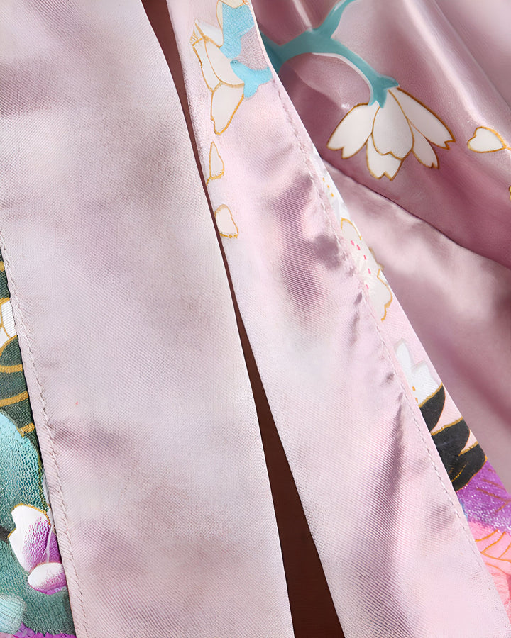 Détail d'un kimono rose avec des motifs floraux délicats. Textile luxueux, idéal pour un look élégant et confortable. Découvrez notre collection de kimonos uniques.