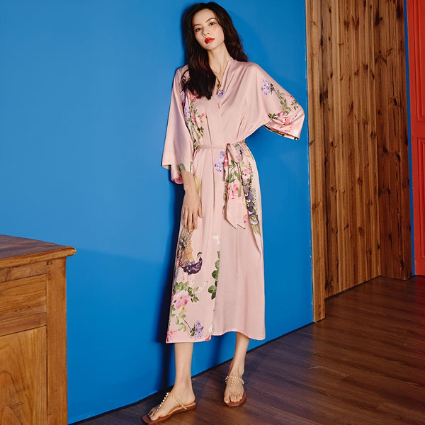 Femme portant un kimono rose à motifs floraux. Vêtements de détente japonais élégants. Découvrez notre collection de kimonos.