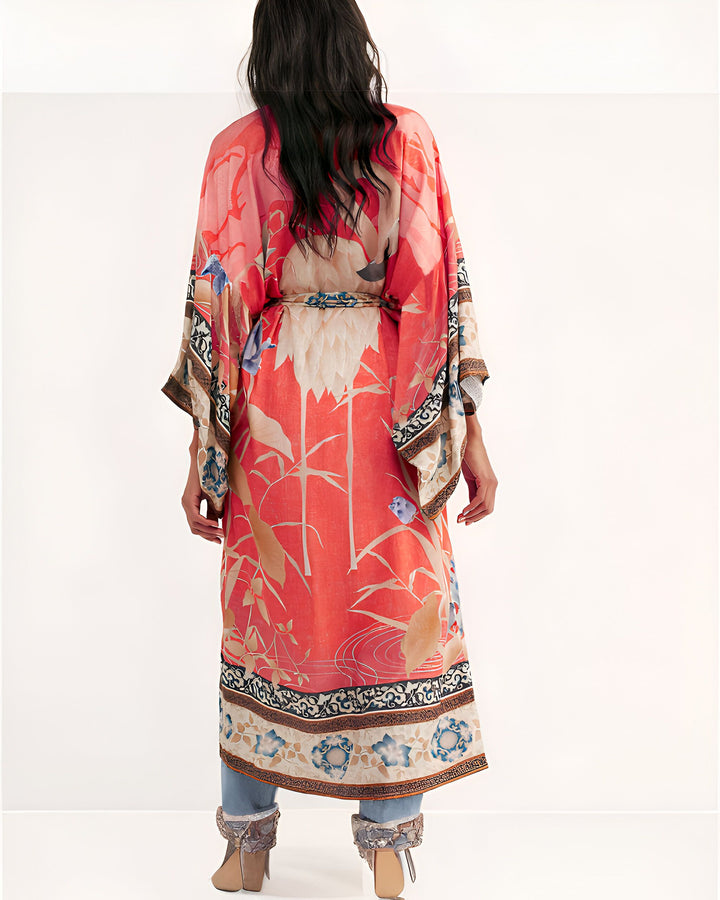Kimono long rouge à motifs floraux et végétaux, vue de dos. Vêtement ample avec ceinture, style japonais revisité. Idéal pour un look bohème chic.