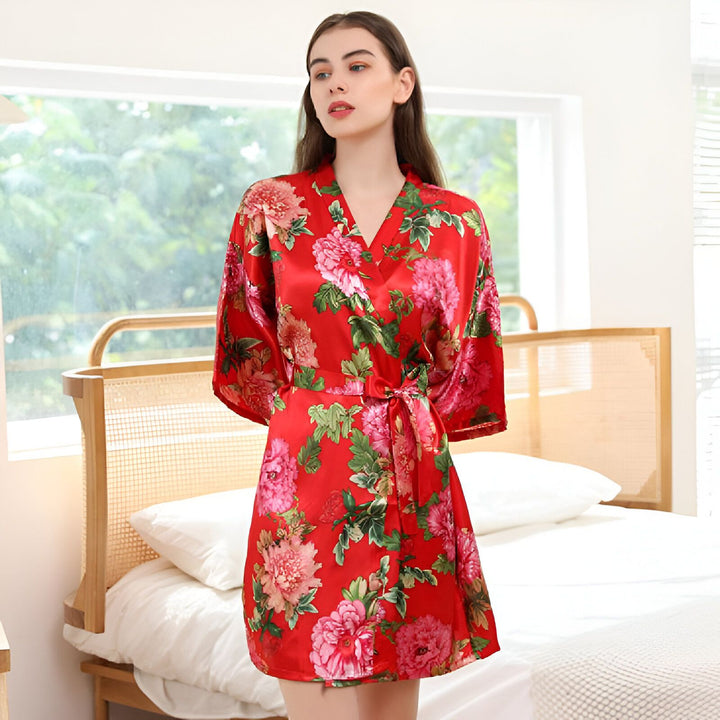 Femme portant un kimono rouge fleuri, robe de chambre élégante. Vêtements japonais traditionnels revisités, vente de kimonos en ligne.