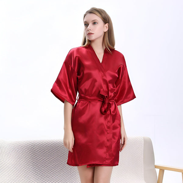 Femme portant un kimono rouge en satin. Peignoir de chambre élégant et confortable. Découvrez nos kimonos de haute qualité.
