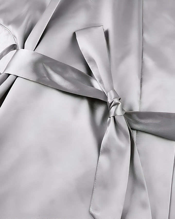 Détail d'un kimono en soie argentée, mettant en valeur la ceinture nouée. Vêtements japonais traditionnels et élégants. Parfait pour se détendre avec style.