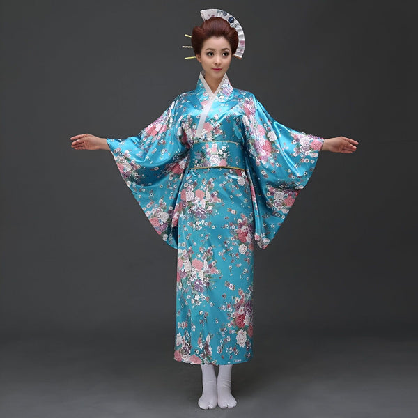 Femme en kimono bleu fleuri avec obi, coiffée d'un éventail traditionnel. Costume japonais typique, élégance et tradition.