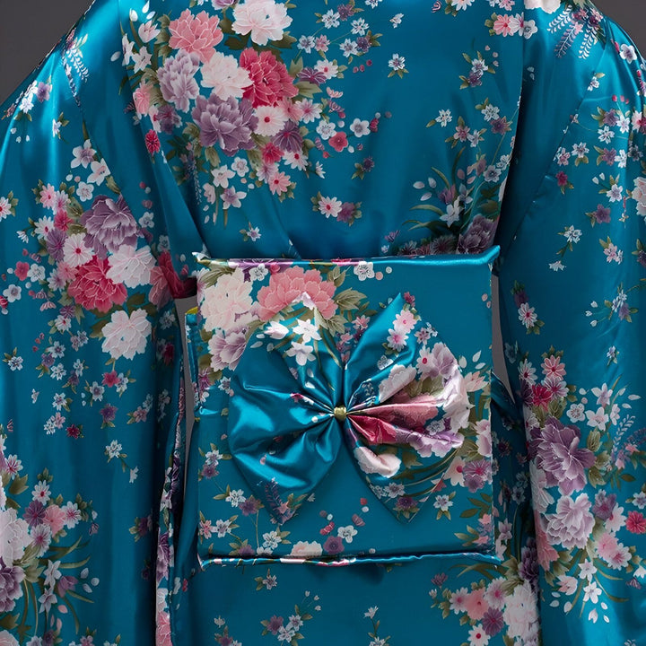 Détail d'un kimono bleu turquoise à motifs floraux roses et violets. Le obi, également bleu et orné de fleurs, est noué en un grand nœud à l'arrière. Tissu satiné brillant. Mode japonaise traditionnelle.