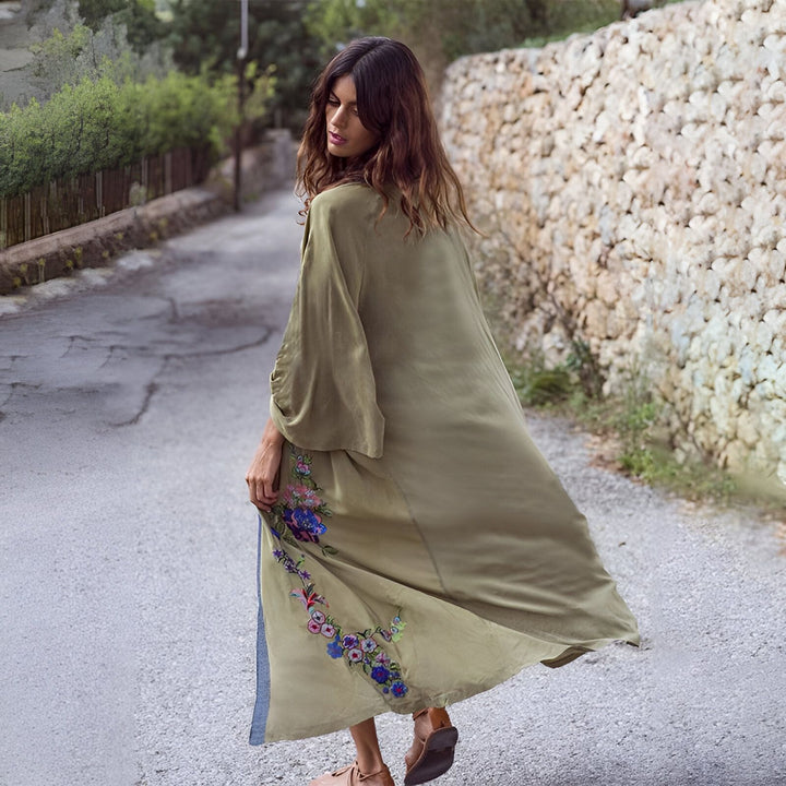 Femme portant un kimono long vert olive avec des broderies florales. Vente de kimonos élégants et confortables. Mode femme, vêtement de détente.
