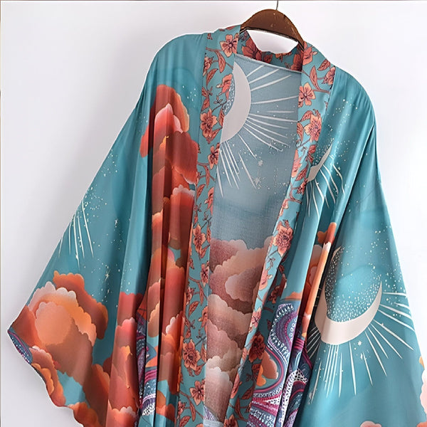 Kimono turquoise imprimé lune, nuages et fleurs, suspendu à un cintre. Vêtements japonais pour femme. Boutique de kimonos en ligne.