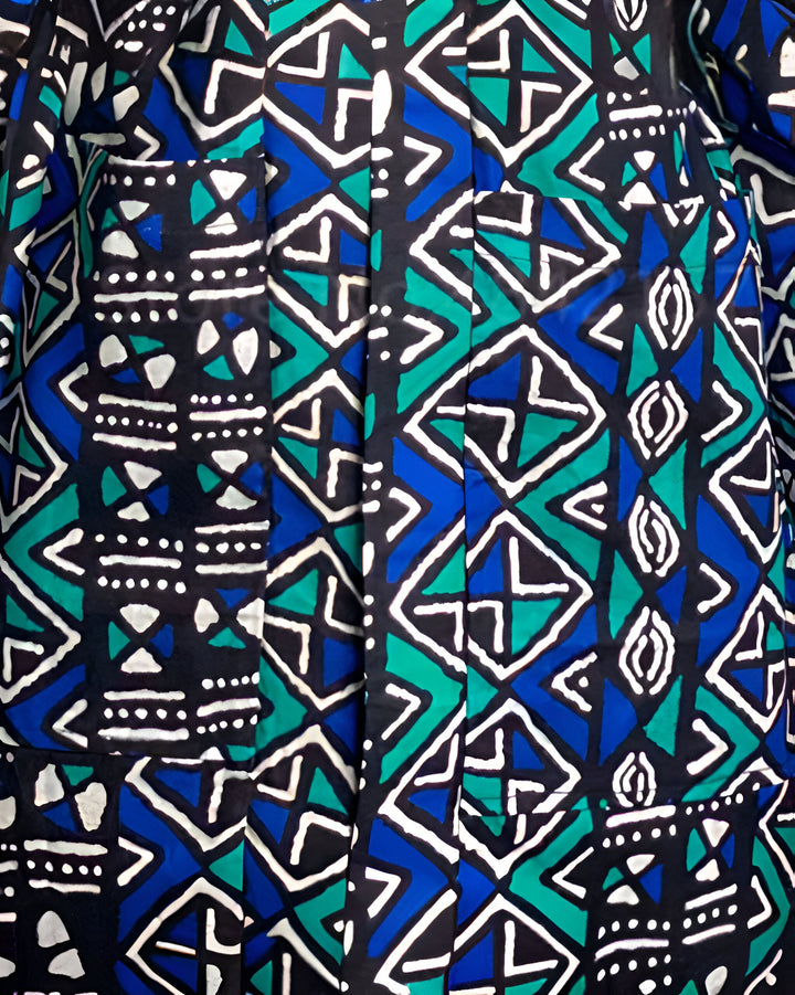 Détail d'un kimono avec un motif géométrique bleu, turquoise et blanc sur fond noir. Motifs ethniques et poches visibles. Kimono à motifs pour un style unique.