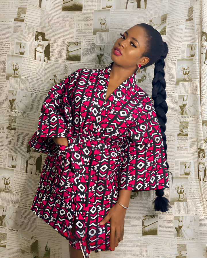 Femme portant un kimono rose, noir et blanc à motifs géométriques. Kimonos de qualité supérieure à découvrir sur notre site.