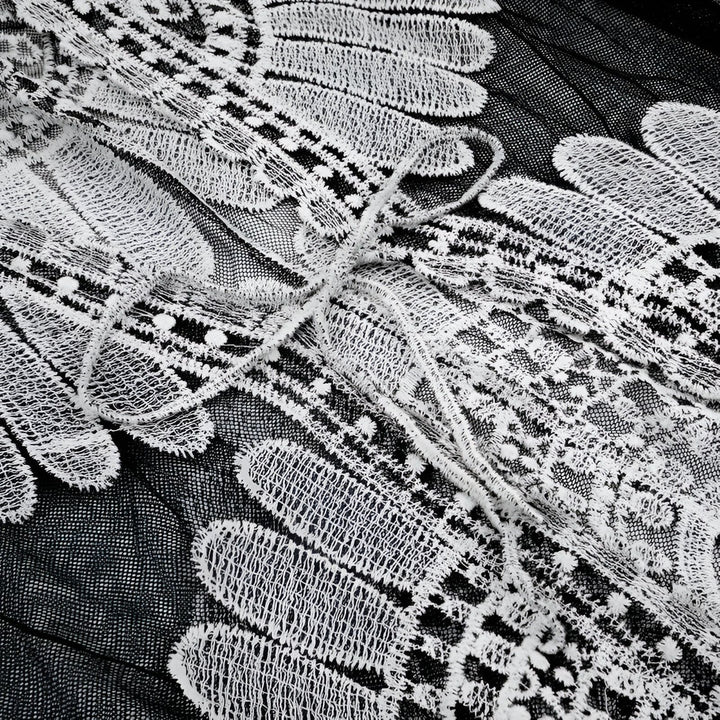 Détail de tissu en dentelle blanche sur fond noir, kimono élégant. Texture délicate, motif floral complexe. Vêtement raffiné, style japonais traditionnel. Parfait pour une tenue sophistiquée.