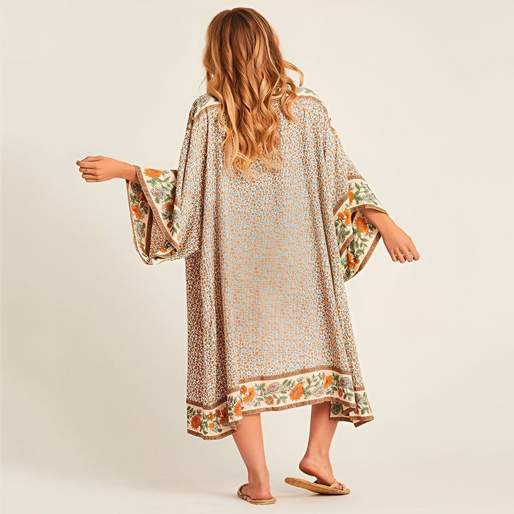 Femme portant un kimono à motifs floraux, vue de dos. Kimono long et ample, avec des manches larges et des détails floraux sur les bords. Vêtements de style kimono.